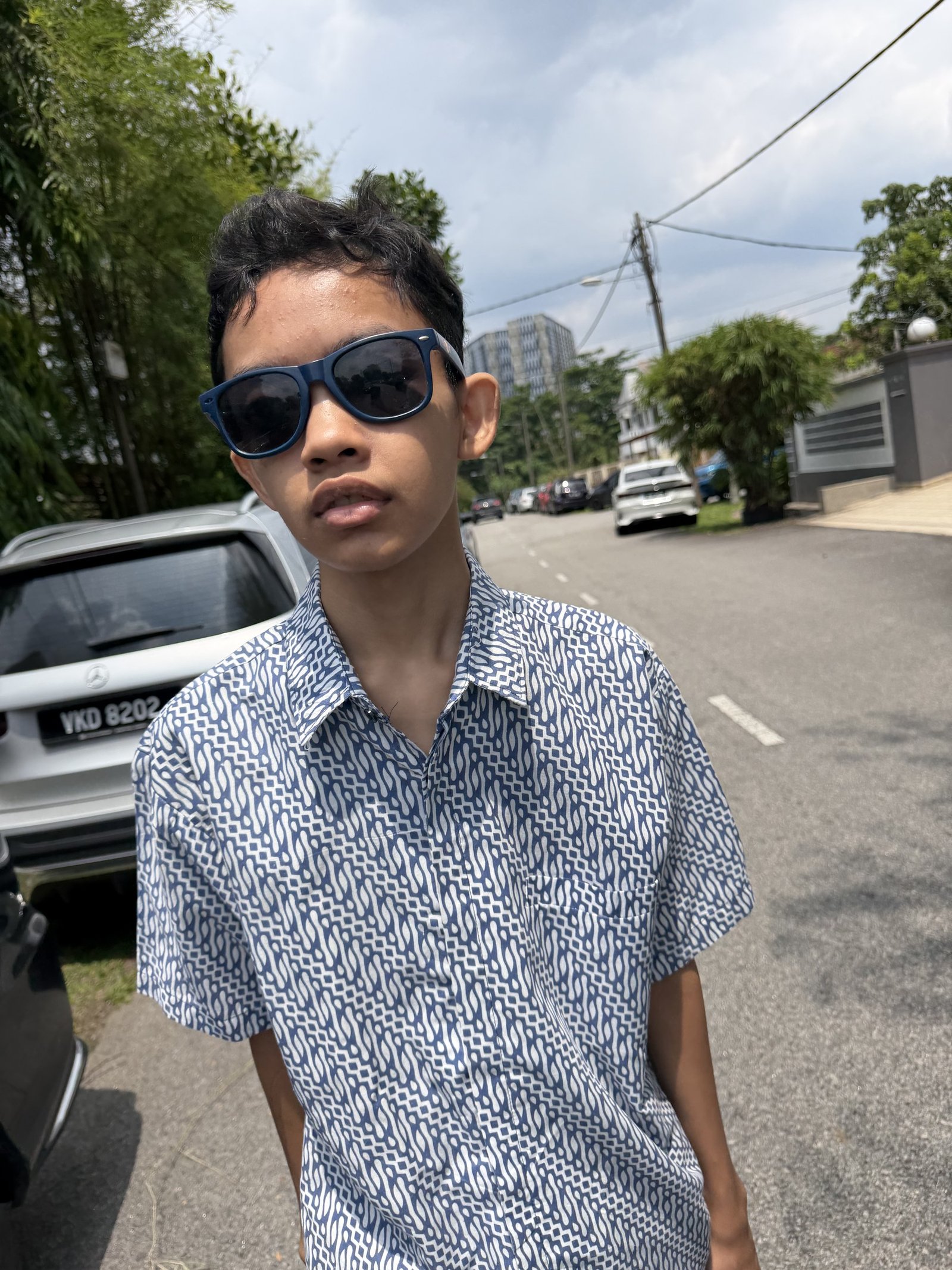 Raees Aryan Ezmir smiling outdoors in a batik shirt