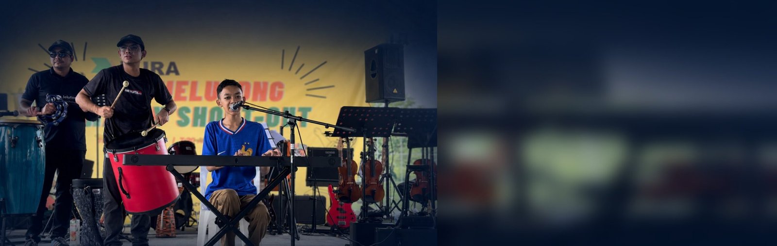 Raees, an autistic pianist, singing and playing keyboard on stage during a live community performance